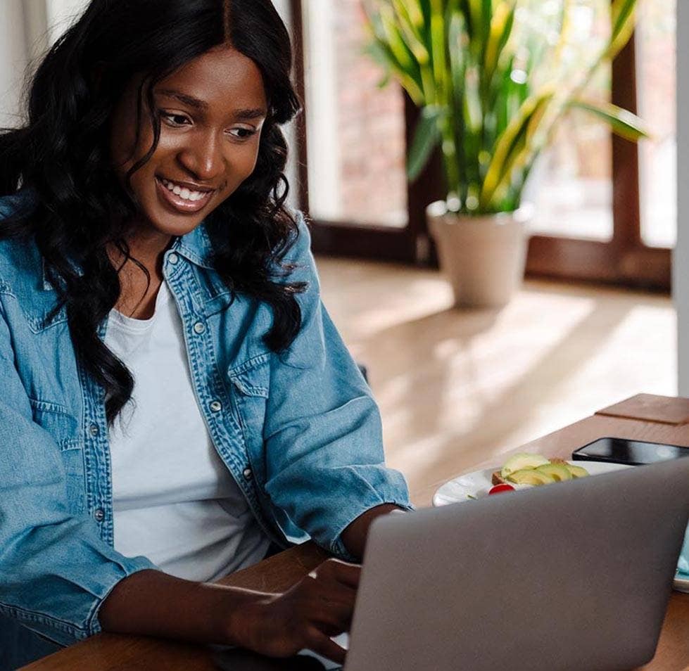 woman using laptop while having lunch