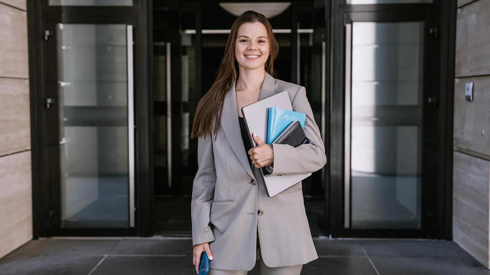 Smiling professional woman carrying folders