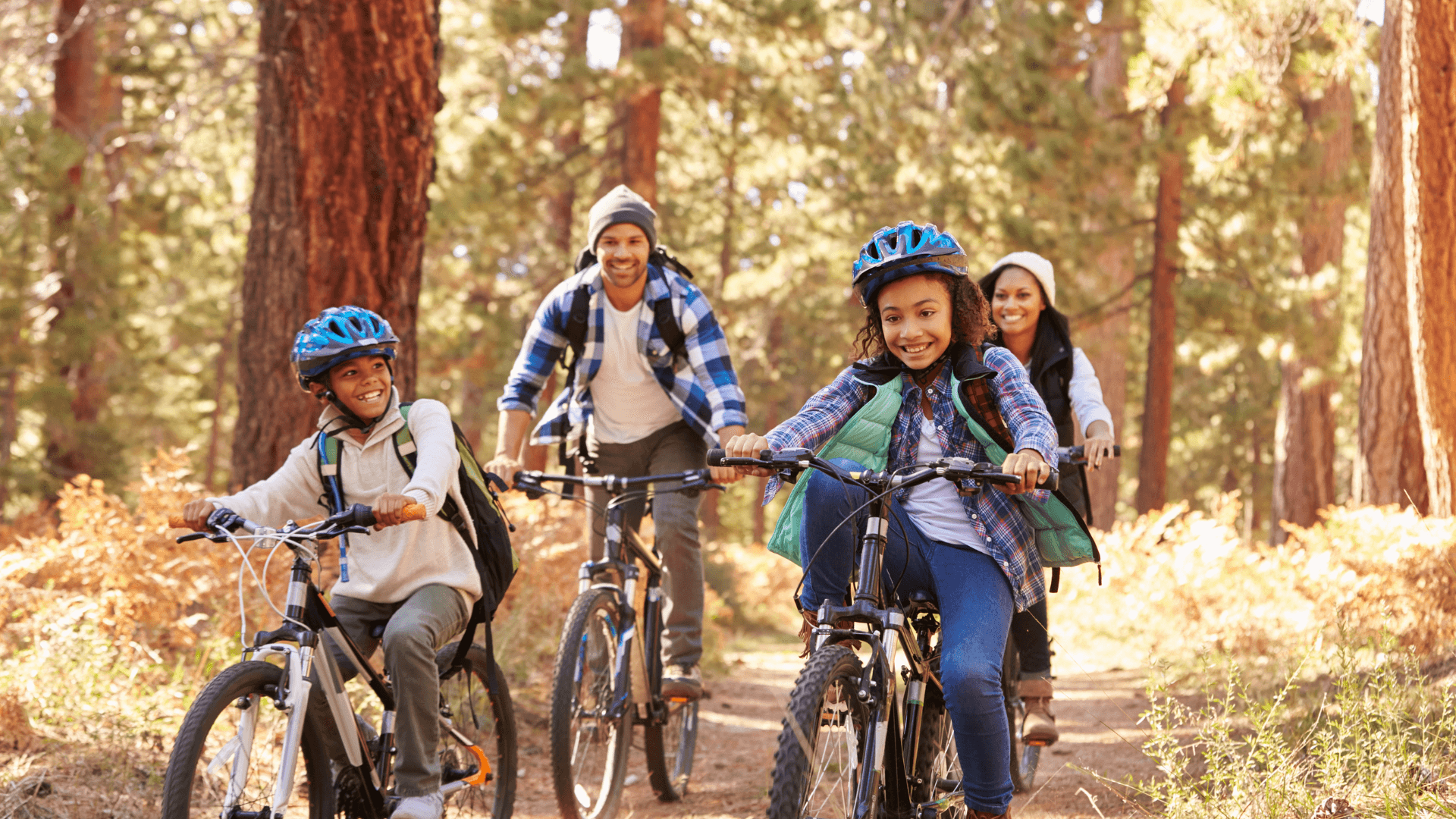 family riding bikes through the woods