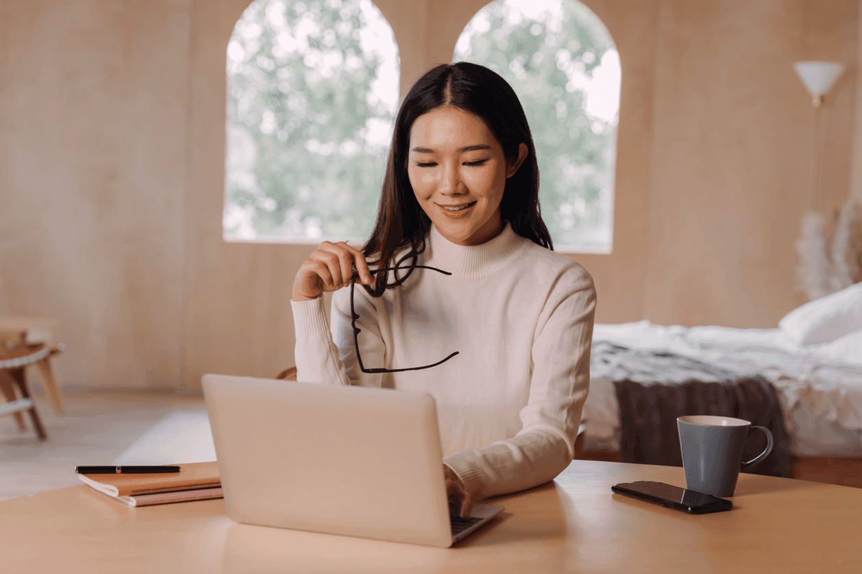 Lawyer holding glasses looking at a laptop