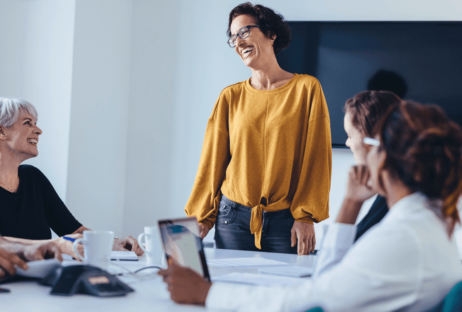 Lady in a yellow top stood in a meeting room