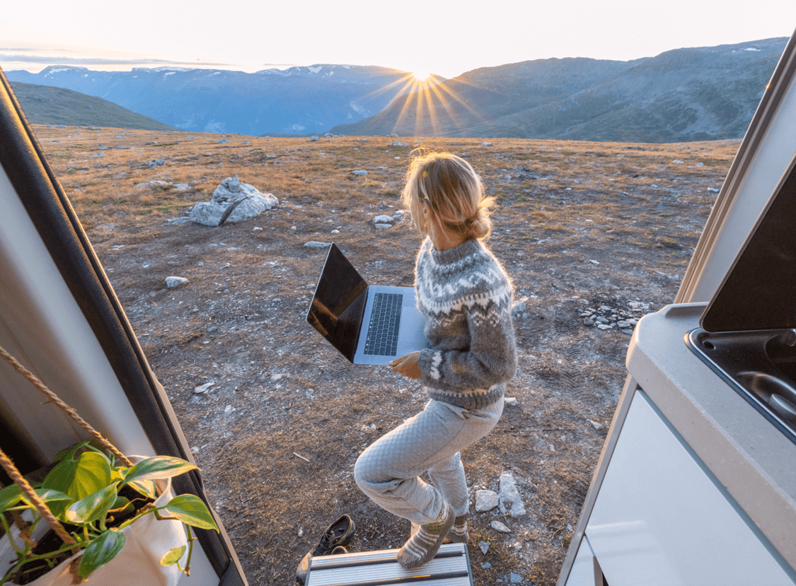 Person working in the countryside with a laptop
