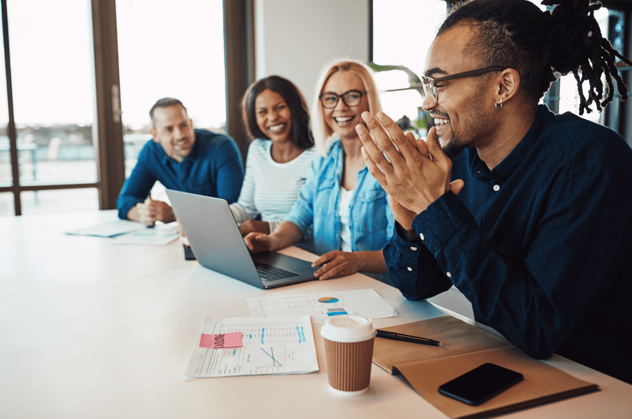 4 people smiling in a meeting room