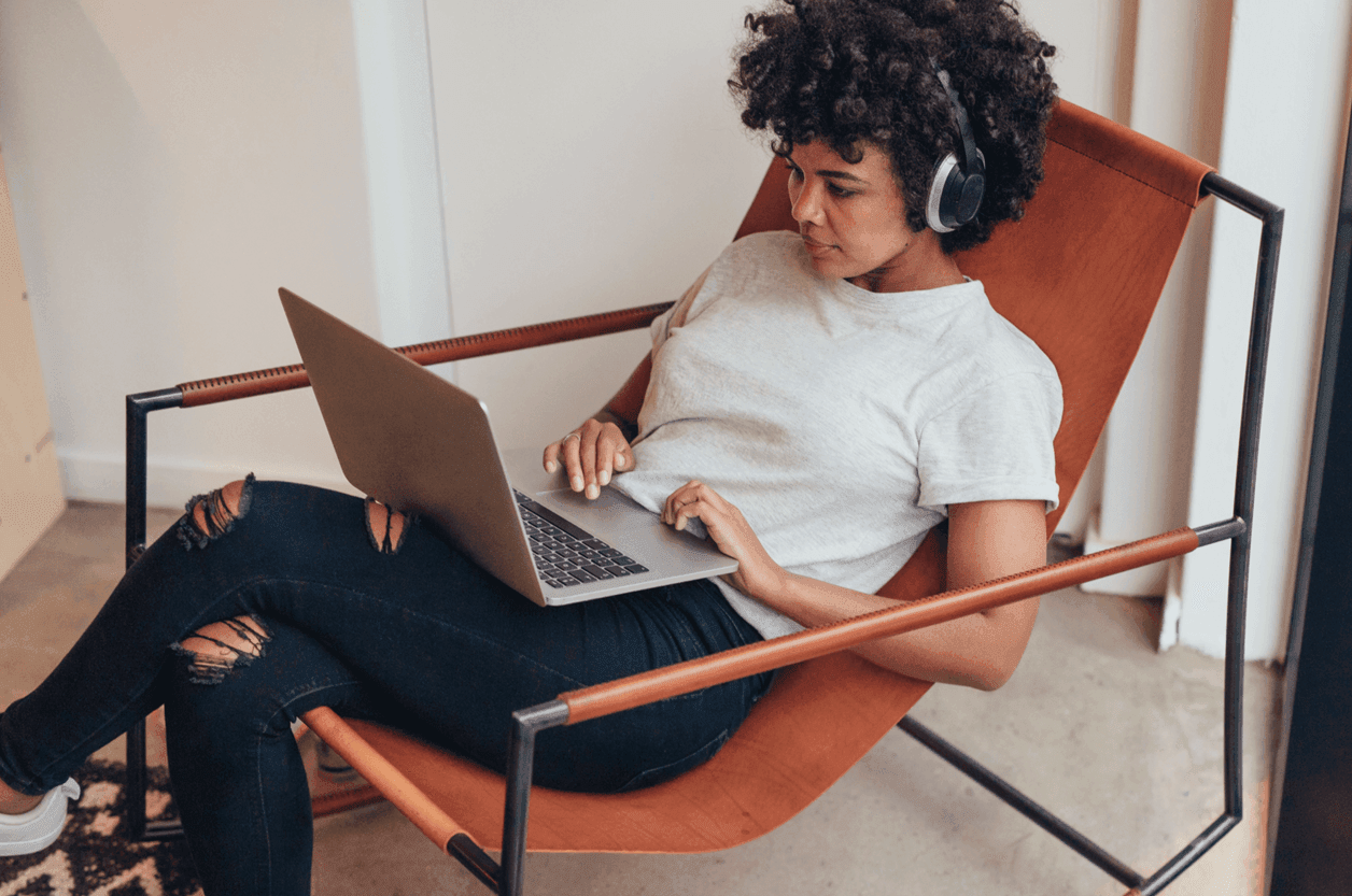 Lawyer sitting on a chair with her laptop and headphone on.