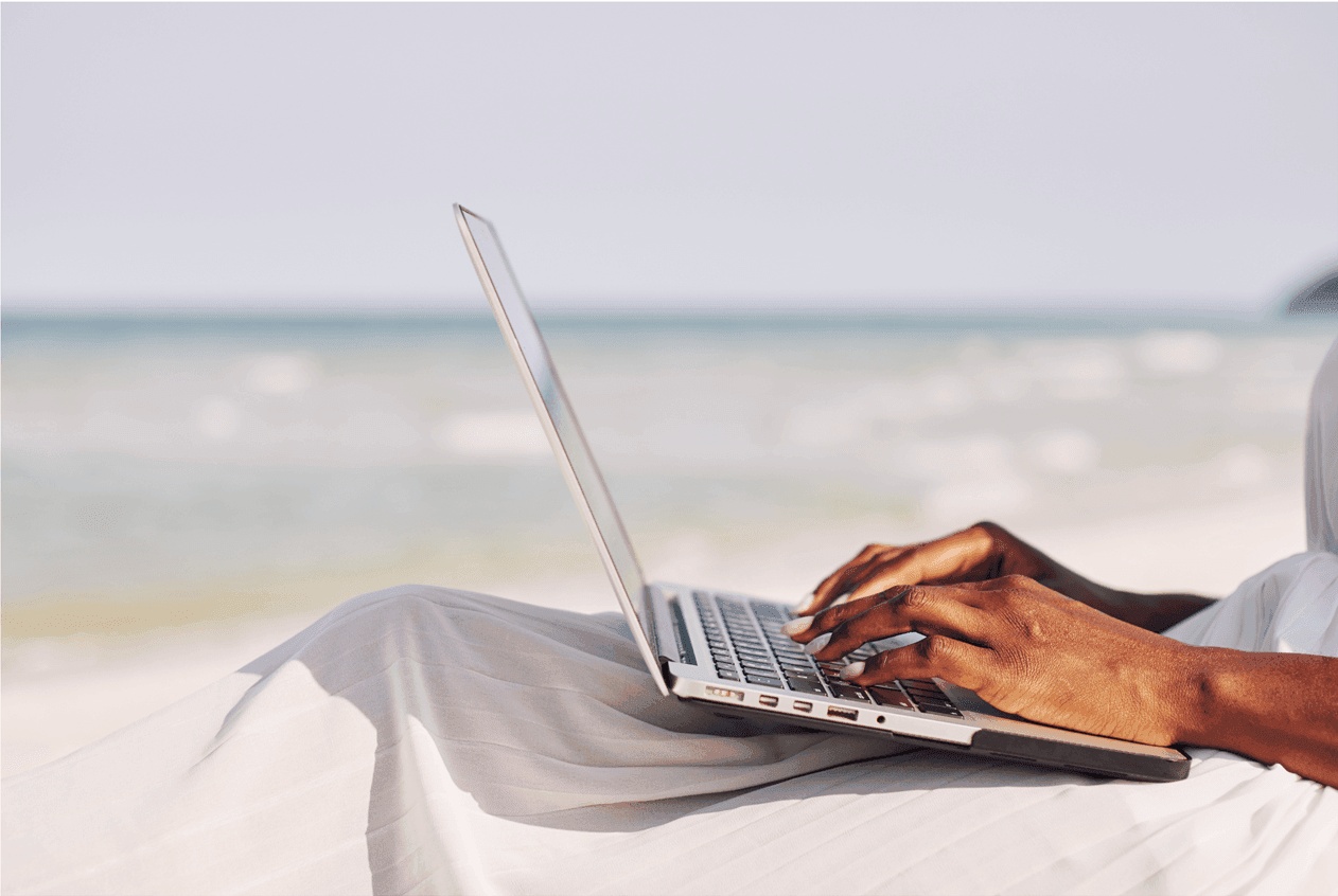 person with laptop on a beach