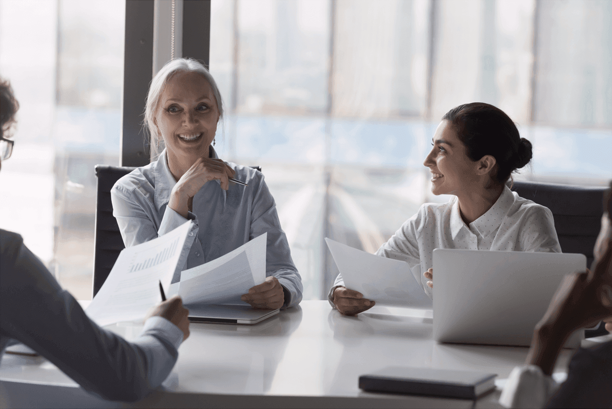 3 people talking whilst holding paperwork