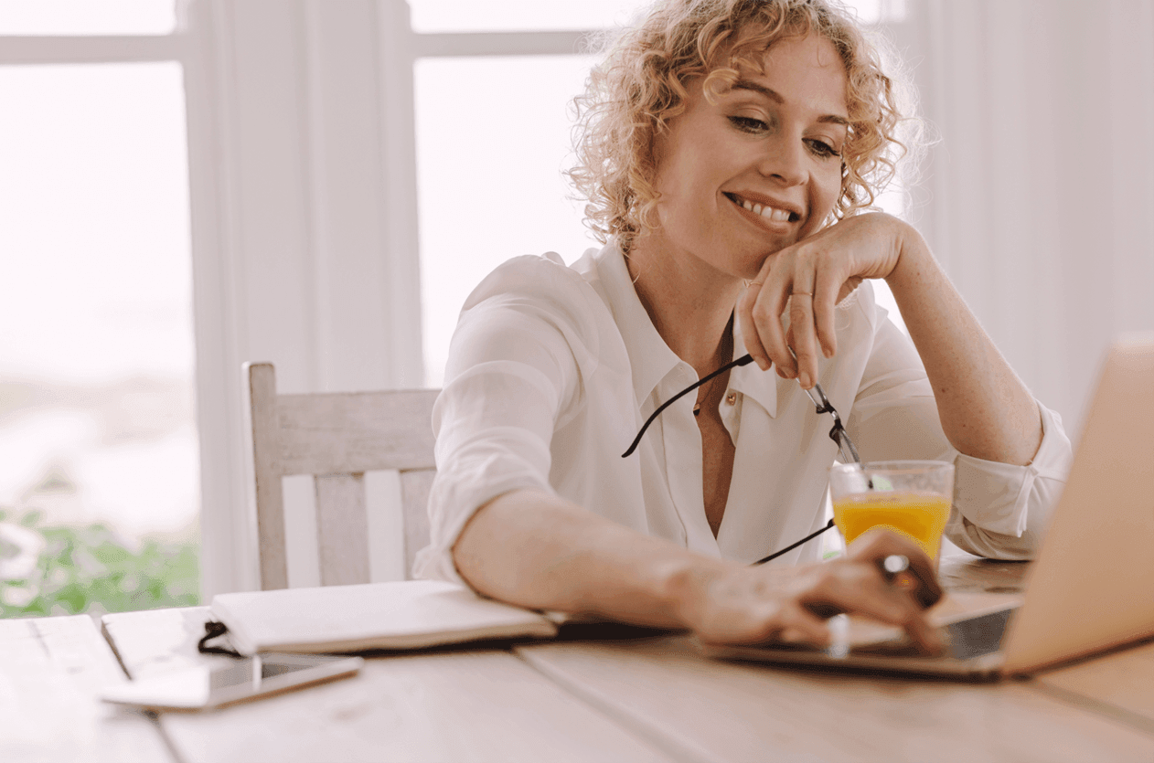 Person holding glasses whilst on laptop